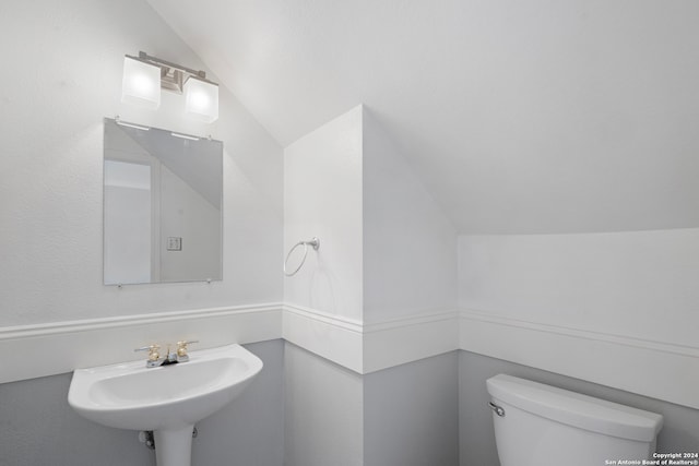 bathroom featuring lofted ceiling, sink, and toilet