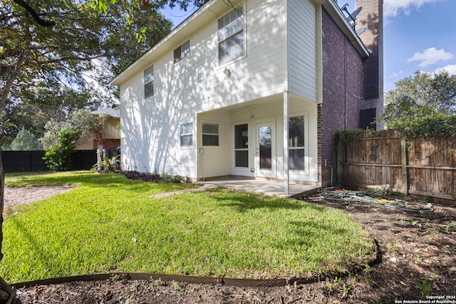 back of property with a patio area and a yard