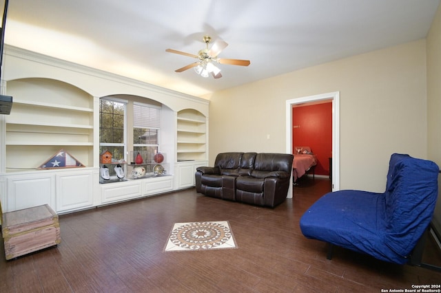 living area with a ceiling fan, dark wood finished floors, and built in shelves
