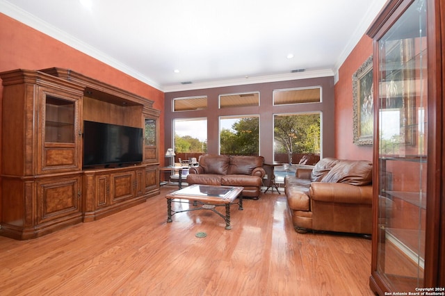 living area with light wood-style flooring and crown molding