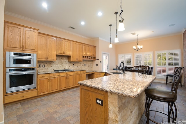 kitchen featuring light stone counters, crown molding, sink, and hanging light fixtures