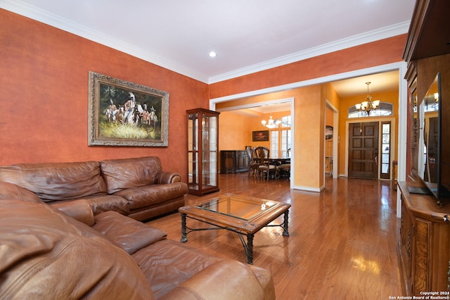 living room with a chandelier, wood-type flooring, and ornamental molding