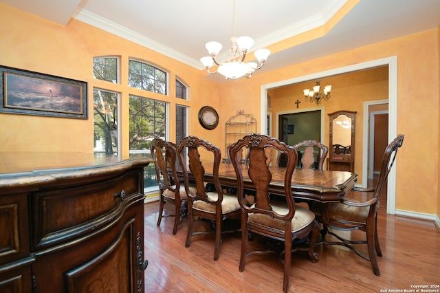 dining room featuring light wood-type flooring, crown molding, and a chandelier