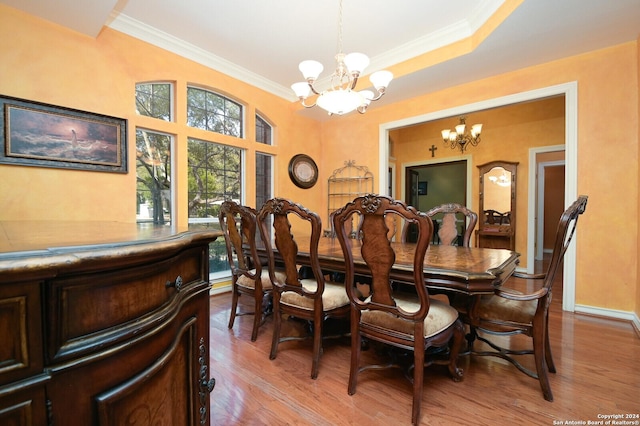 dining room with a chandelier, ornamental molding, light wood-style floors, and baseboards