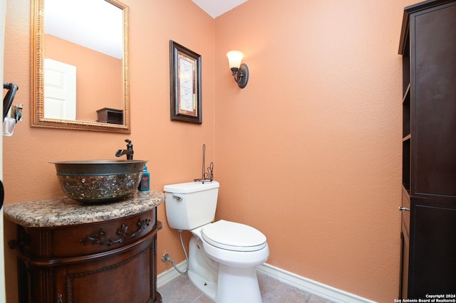 bathroom featuring baseboards, tile patterned floors, toilet, and vanity