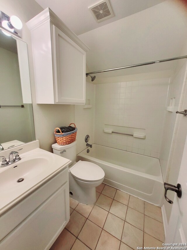 full bathroom with toilet, tiled shower / bath, vanity, and tile patterned flooring