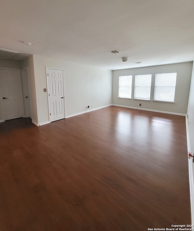 empty room with dark hardwood / wood-style flooring