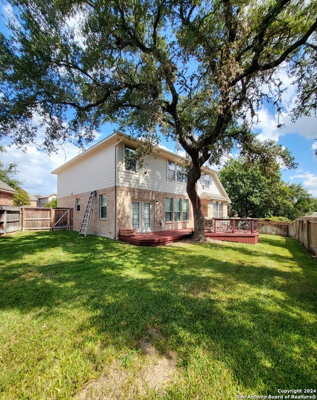 back of property featuring a yard and a deck