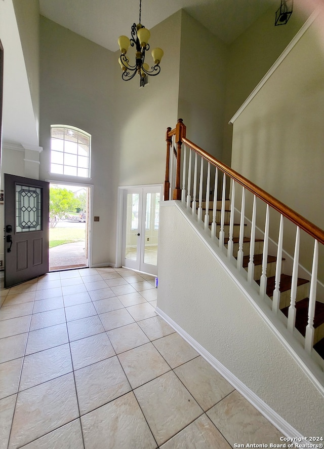 entrance foyer with an inviting chandelier, a high ceiling, and light tile patterned floors