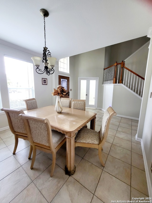 tiled dining room featuring french doors and a chandelier