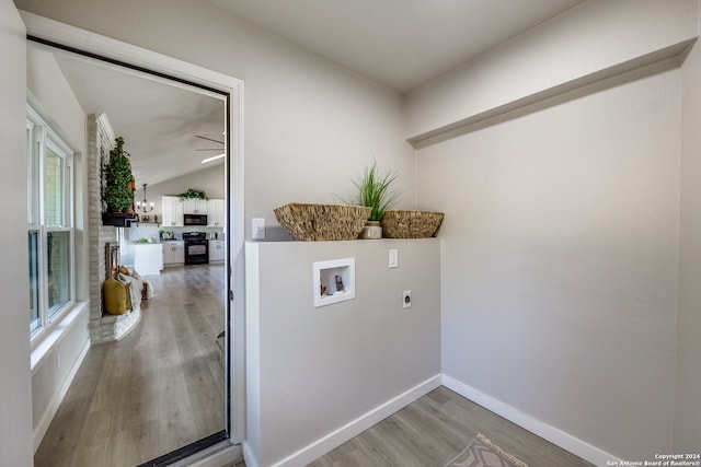 clothes washing area featuring hardwood / wood-style flooring, electric dryer hookup, and washer hookup