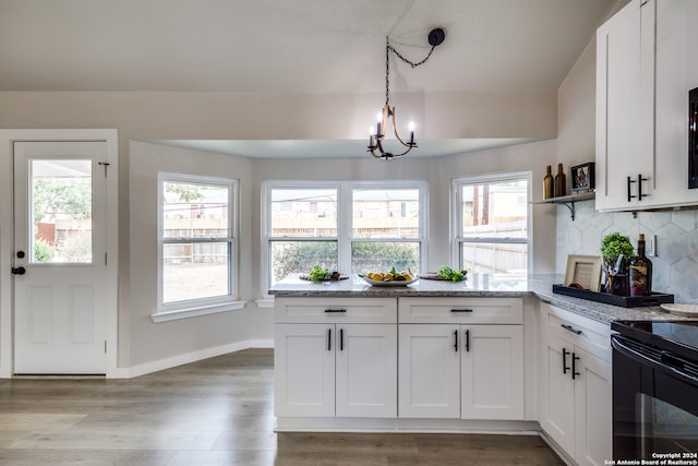 kitchen with tasteful backsplash, white cabinetry, wood-type flooring, and pendant lighting