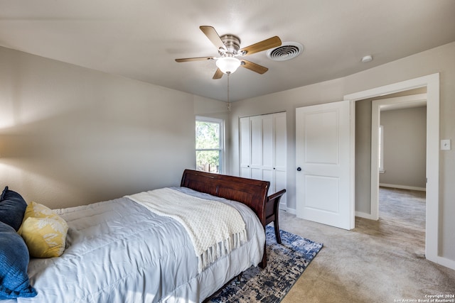 bedroom featuring light carpet, ceiling fan, and a closet