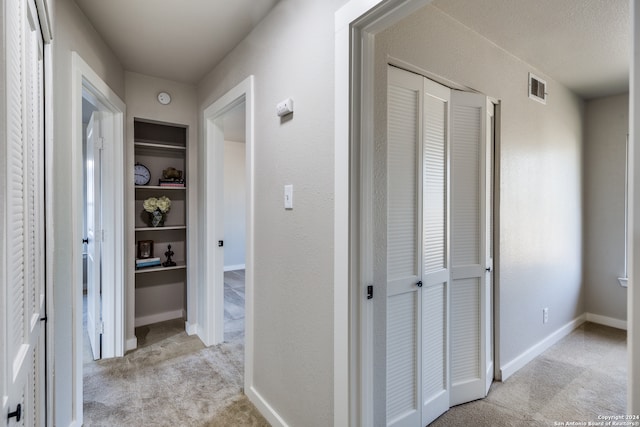 hall with light colored carpet