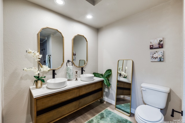 bathroom featuring wood-type flooring, vanity, and toilet