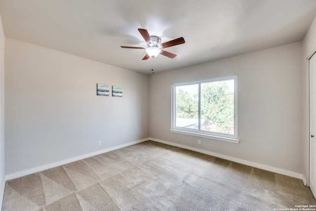 empty room with ceiling fan and light colored carpet