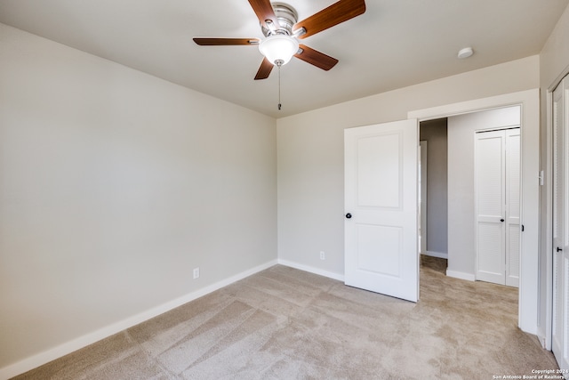 unfurnished bedroom featuring ceiling fan, a closet, and light carpet