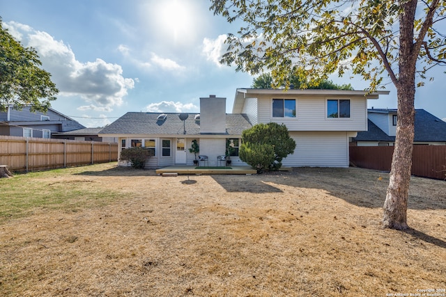 rear view of property featuring a wooden deck and a yard