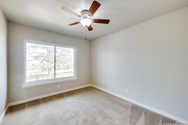 carpeted spare room with ceiling fan