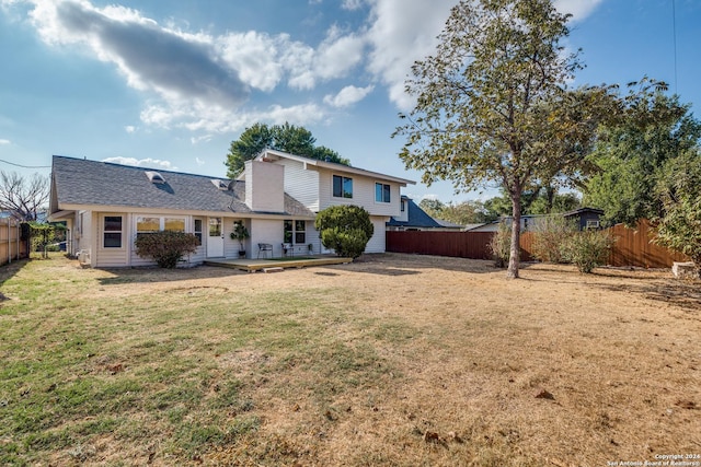 rear view of property with a lawn