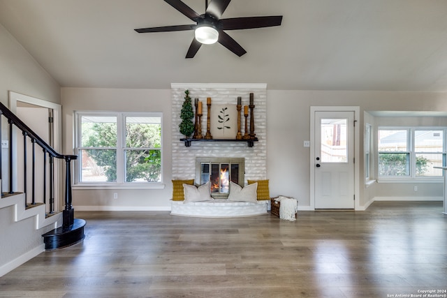 unfurnished living room with hardwood / wood-style flooring, plenty of natural light, lofted ceiling, and a fireplace