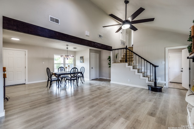 dining area with high vaulted ceiling, ceiling fan with notable chandelier, and light hardwood / wood-style floors