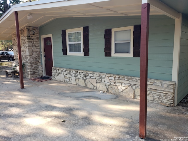 view of side of home featuring covered porch