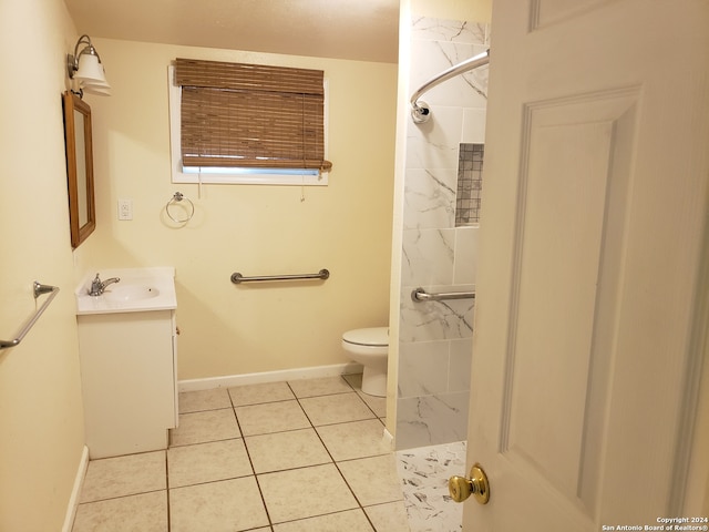 bathroom featuring vanity, toilet, tiled shower, and tile patterned flooring