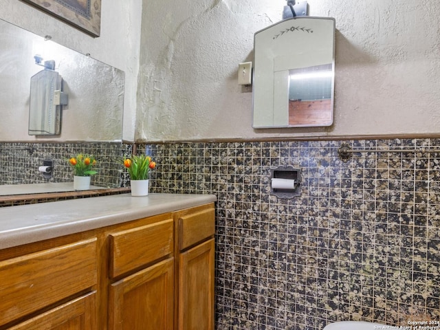 1315 Alametos, San Antonio, TX 78201 - bathroom featuring a textured wall, wainscoting, tile walls, and vanity