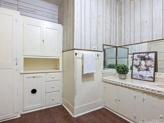 bathroom with wood walls and wood-type flooring