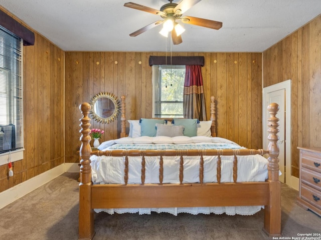 carpeted bedroom with ceiling fan and wooden walls