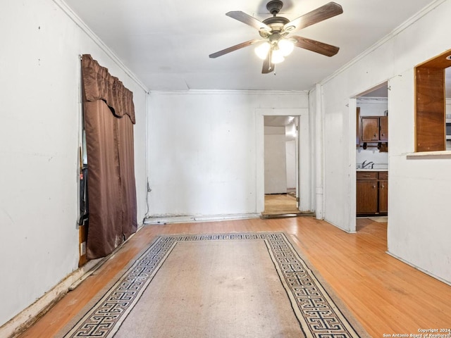 spare room with light hardwood / wood-style floors, ornamental molding, and ceiling fan