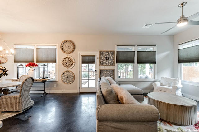 living room with a healthy amount of sunlight and ceiling fan with notable chandelier