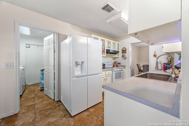 kitchen with white appliances, washer / clothes dryer, sink, white cabinets, and range hood