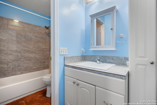 full bathroom featuring tiled shower / bath, vanity, a textured ceiling, and toilet