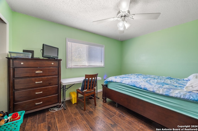 bedroom with ceiling fan, a textured ceiling, and dark hardwood / wood-style flooring