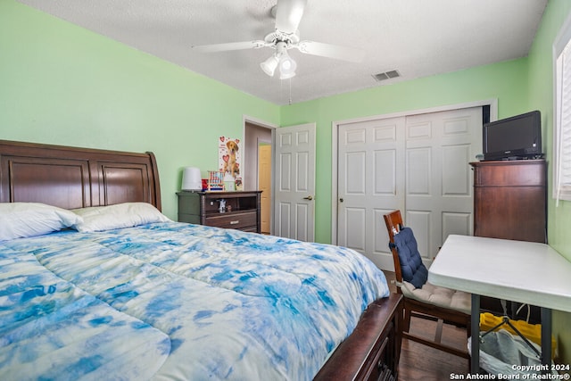 bedroom featuring a closet, ceiling fan, a textured ceiling, and dark wood-type flooring