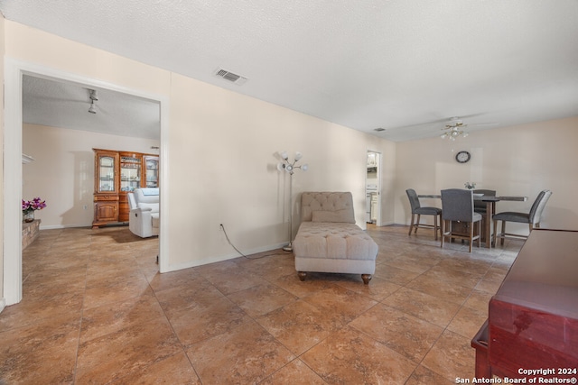 living area featuring a textured ceiling and ceiling fan