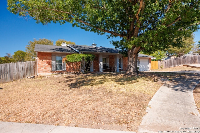 ranch-style home featuring a garage and a front lawn