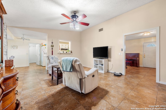 living room with lofted ceiling, a textured ceiling, and ceiling fan