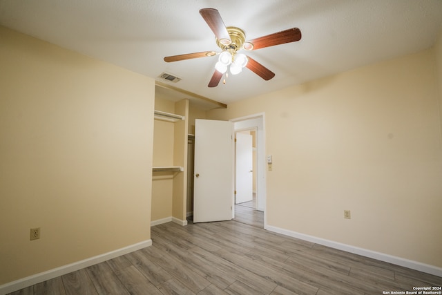 unfurnished bedroom featuring a closet, light wood-type flooring, and ceiling fan