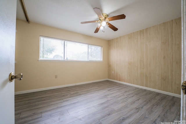 empty room featuring a textured ceiling, wood-type flooring, and ceiling fan