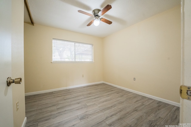 empty room featuring ceiling fan, a textured ceiling, and light hardwood / wood-style flooring