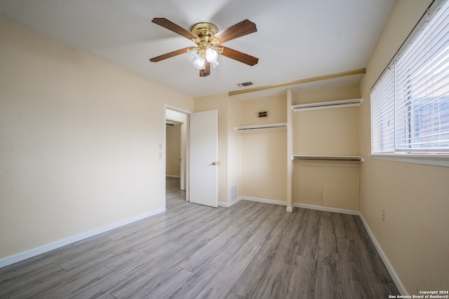 unfurnished bedroom with a closet, hardwood / wood-style floors, and ceiling fan