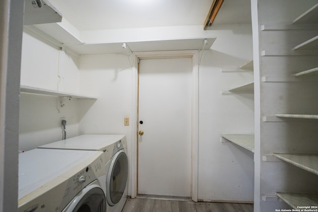 washroom featuring washing machine and clothes dryer and light hardwood / wood-style floors