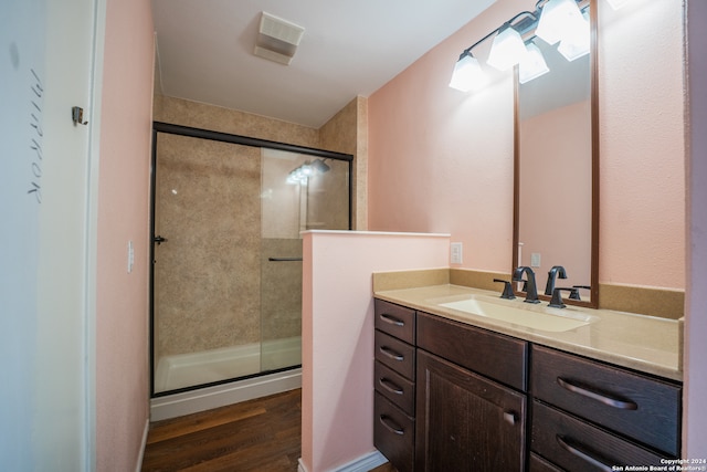 bathroom featuring vanity, wood-type flooring, and a shower with shower door