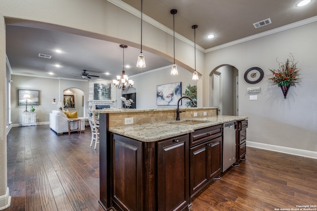 kitchen with dark wood-type flooring, an island with sink, dark brown cabinetry, and a fireplace