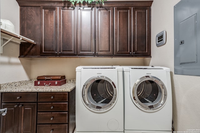 laundry room featuring cabinets, washer and dryer, and electric panel