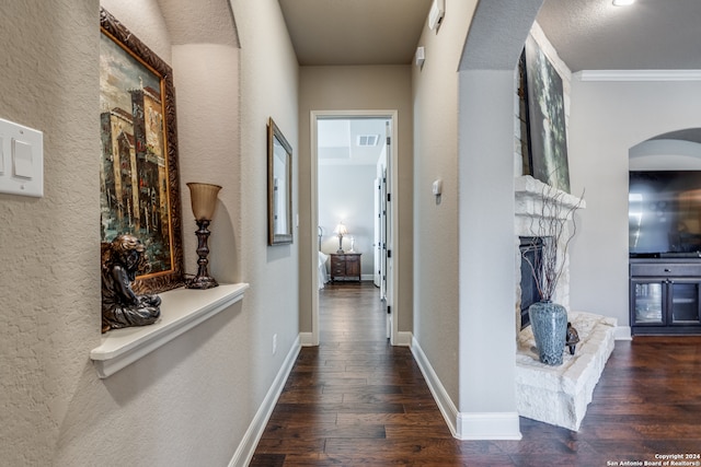 corridor with ornamental molding and dark wood-type flooring