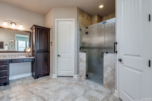 bathroom with a shower with door and vanity